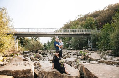 dağlar, Anne, baba ve Oğlu Asya gülmek ve kucaklama nehir yakınındaki bir yolda mutlu Kore aile
