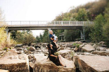 dağlar, Anne, baba ve Oğlu Asya gülmek ve kucaklama nehir yakınındaki bir yolda mutlu Kore aile