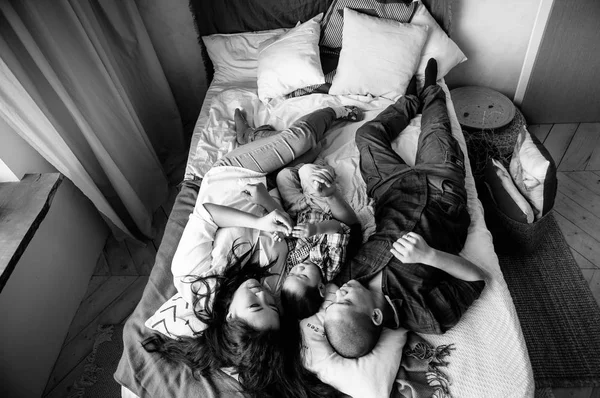 Black and white view of korean family laying on bed