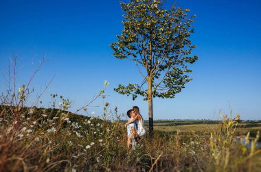 Yavaşça elele ağaçları arasında dağlarda yaz aylarında bir yolda sevgi dolu Çift