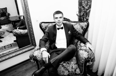 yakışıklı damat vintage bir sandalyede oturuyor