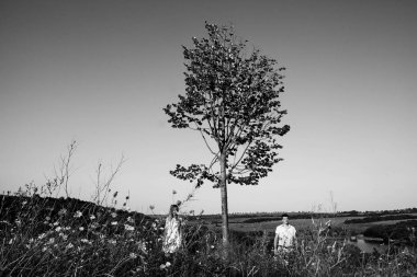 Yavaşça elele ağaçları arasında dağlarda yaz aylarında bir yolda sevgi dolu Çift