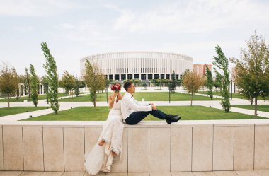 şık gelin ve damat bir parkta bir yürüyüş-onların düğün günü içinde stadyumun yakınındaki