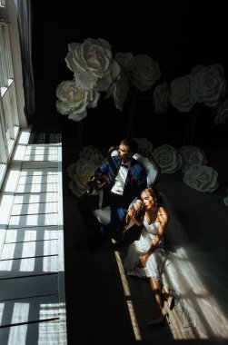 şık gelin ve Damat Düğün fotoğraf oturumunda stüdyoda, sevgi dolu birkaç gülüyor ve hugs