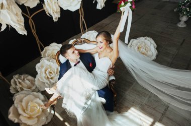 şık gelin ve Damat Düğün fotoğraf oturumunda stüdyoda, sevgi dolu birkaç gülüyor ve hugs