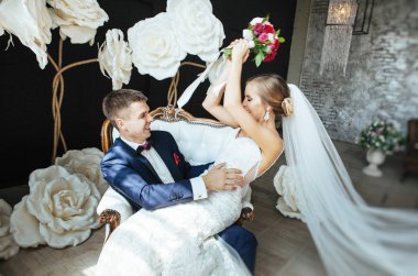 şık gelin ve Damat Düğün fotoğraf oturumunda stüdyoda, sevgi dolu birkaç gülüyor ve hugs