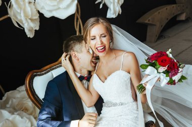 şık gelin ve Damat Düğün fotoğraf oturumunda stüdyoda, sevgi dolu birkaç gülüyor ve hugs