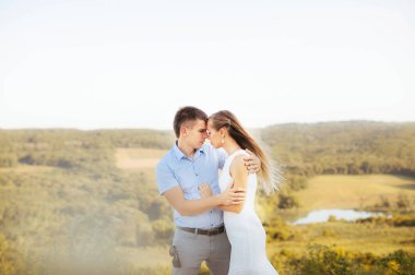 aşık çift şefkatle birbirlerine bakar ve dağlarda yaz yürüyüşe kucaklayan