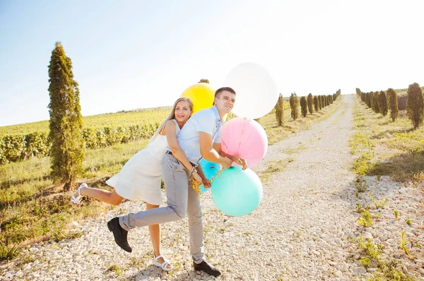 Εραστές Γελάει Και Αγκαλιάζονται Για Μια Βόλτα Καλοκαίρι Κρατώντας Μπαλόνια — Φωτογραφία Αρχείου