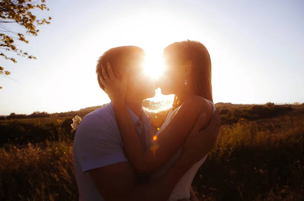 in love couple on a walk in the summer in the mountains at sunset, gently look at each other