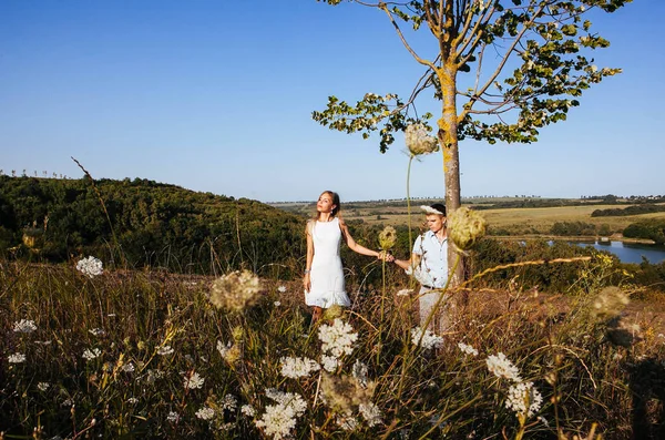 loving couple on a walk in the summer in the mountains among the trees, gently holding hands