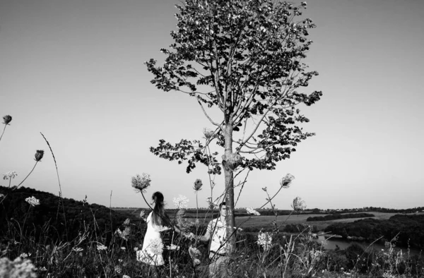 loving couple on a walk in the summer in the mountains among the trees, gently holding hands