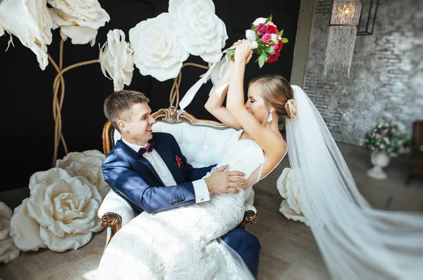 şık gelin ve Damat Düğün fotoğraf oturumunda stüdyoda, sevgi dolu birkaç gülüyor ve hugs
