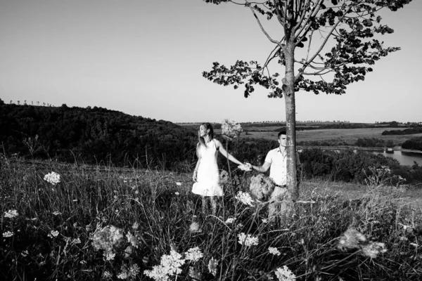 loving couple on a walk in the summer in the mountains among the trees, gently holding hands