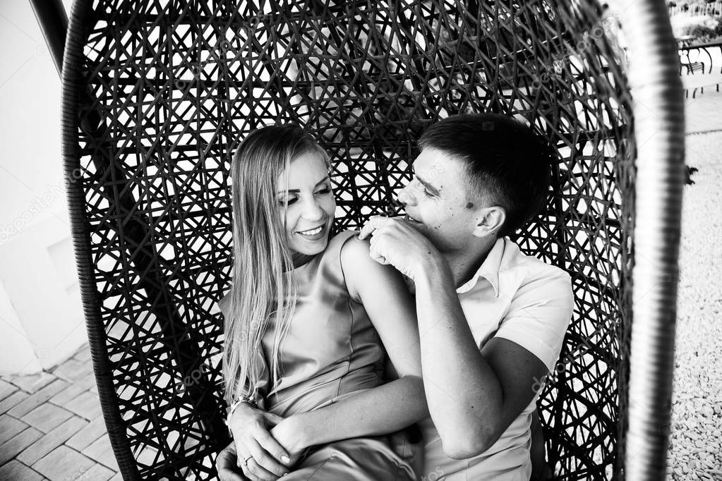 happy couple in love hugging in a hanging chair, tender and positive emotions