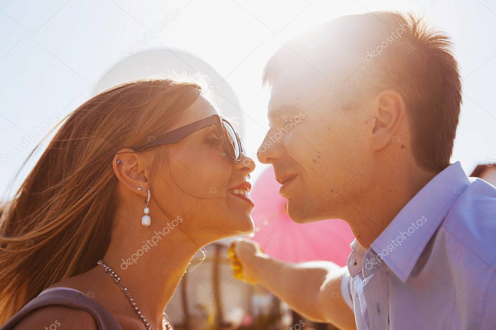 stylish couple in love on a walk in nature at sunset with balloons, tender emotions of love