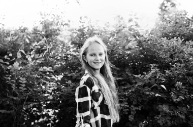 yeşil bir park, pozitif kız öğrenci poz bir ekose gömlek giymiş sarışın genç kız