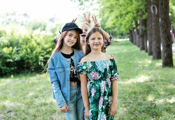 十代の女の子が歩く 笑うし 肯定的な中学生のための緑豊かな公園で遊ぶ — ストック写真