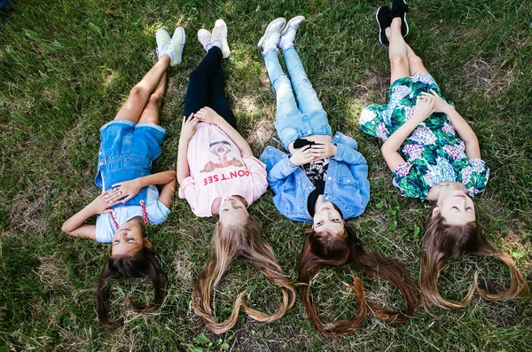 Μαλλιά Σχήμα Καρδιάς Τέσσερα Κορίτσια Εφήβων Είναι Ξαπλωμένη Στο Γρασίδι — Φωτογραφία Αρχείου
