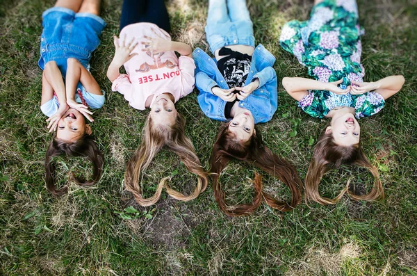 Cabelo Forma Coração Quatro Meninas Adolescentes Estão Deitados Grama Positiva — Fotografia de Stock