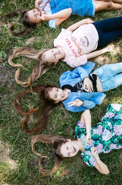 Cabelo Forma Coração Quatro Meninas Adolescentes Estão Deitados Grama Positiva — Fotografia de Stock