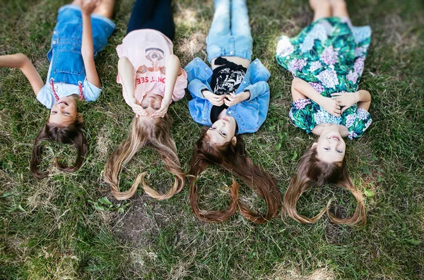 Włosy Kształcie Serca Cztery Nastolatki Dziewczyny Leżąc Trawie Dziewczyna Uczennica — Zdjęcie stockowe