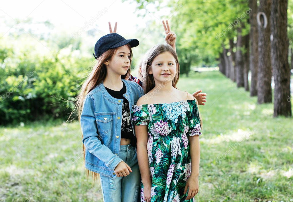 teen girls walk, laugh and play in a green park for a break, positive schoolgirls
