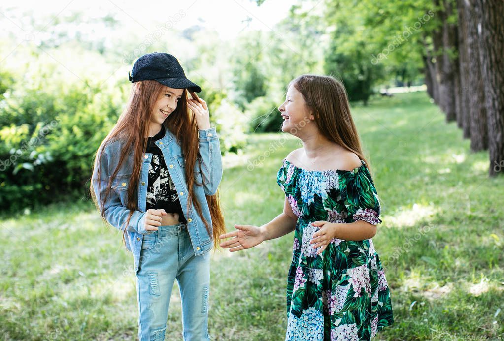 teen girls walk, laugh and play in a green park for a break, positive schoolgirls