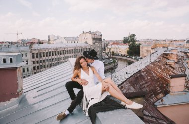 seven çift - beyaz elbise ve şapka bir adamla bir kız - sarılma ve gülüyor, şehrin pozitif ve samimi duygular aşk çatısı görünümünden çatıda bir yolda