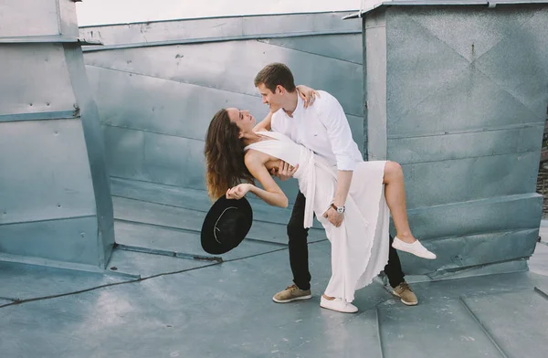 愛の感情を肯定的な誠実な屋根の上歩くカップル 白いドレスと帽子の男の少女 を愛する — ストック写真