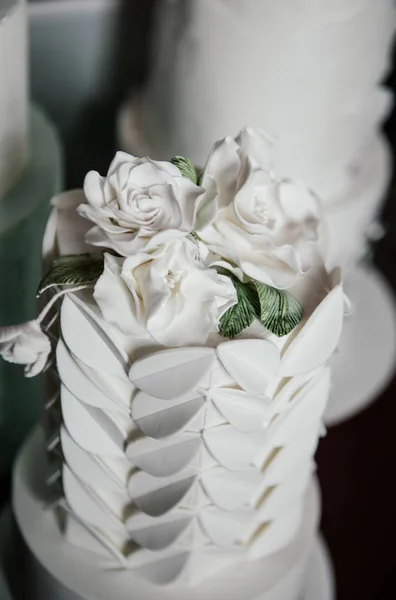 婚礼蛋糕是非常精美的装饰与白色糖霜和马子潘花 — 图库照片