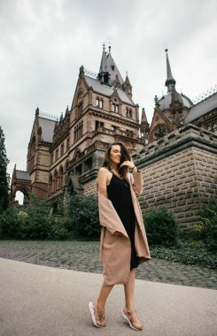 Siyah elbise, pastel pembe ceket ve Ortaçağ Şatosunda poz şapka seksi kız