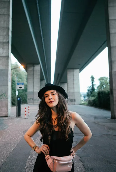 Sexy Brunette Black Dress Hat Pink Purse Poses Stone Bridge — Stock Photo, Image