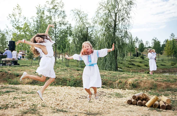 Дві Дівчини Білій Національній Сукні Стрибають Розважаються Язичницькому Весняному Фестивалі — стокове фото