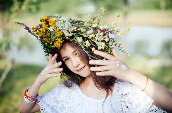 在异教徒的春节里 可爱的女孩穿着白色的民族服装编织着花圈和草 — 图库照片