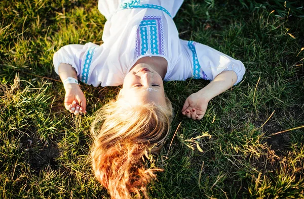 Nettes Blondes Mädchen Weißen Nationalkleid Liegt Auf Dem Gras Und — Stockfoto