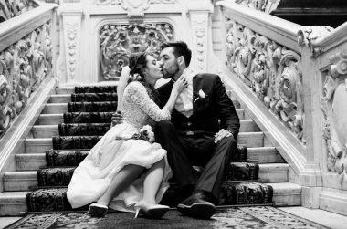 mutlu gelin ve damat merdivenlerden oturan ve Saray, siyah beyaz fotoğraf kayıt olduktan sonra öpüşme 