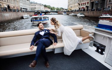 şık gelin ve damat düğün gününde, eğlenmek ve nehir üzerinde bir tekne gezisi gülümseyen 