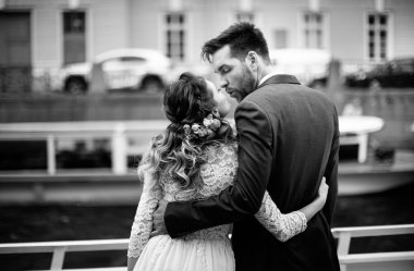 Düğün gününde şık gelin ve damat, nehir üzerinde bir tekne gezisi eğlenmek ve öpüşme, siyah ve beyaz fotoğraf 