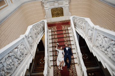 Saray kaydından sonra merdivenlerden yatan mutlu gelin ve damat 