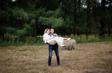 damat, sıradışı bir düğün günü alanında silah onun mutlu gelin taşıyan