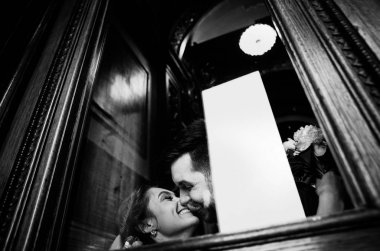 kendi düğün gününde şık gelin ve damat, sarılmak ve şefkatle birbirlerine bakarak, siyah ve beyaz fotoğraf 