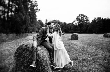 onların düğün gününde şık gelin ve damat, eğlenceli ve sonbahar haystacks, siyah beyaz fotoğraf bir yürüyüşe gülümsüyor 