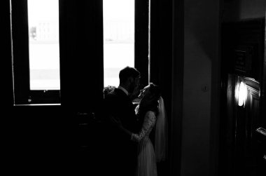 kendi düğün gününde şık gelin ve damat, sarılmak ve şefkatle birbirlerine bakarak, siyah ve beyaz fotoğraf 