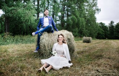 onların düğün gününde şık gelin ve damat, eğlenceli ve sonbahar haystacks bir yürüyüşe gülümsüyor