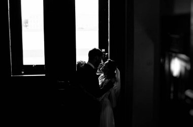 kendi düğün gününde şık gelin ve damat, sarılmak ve şefkatle birbirlerine bakarak, siyah ve beyaz fotoğraf 