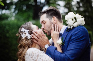 bir bahar parkında sarılma ve öpüşme onların düğün gününde şık gelin ve damat 