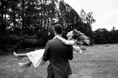 alan, olağandışı bir düğün günü, siyah ve beyaz fotoğraf silah onun mutlu gelin taşıyan damat 