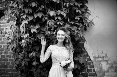 bir parkta düğün gününde buket ile sarışın gelin portre, siyah ve beyaz fotoğraf 