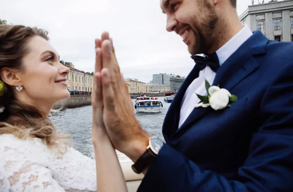 彼らの結婚式の日にスタイリッシュな新郎新婦は 川のボート旅行に楽しさとキスを持って — ストック写真